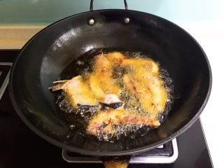 红烧鱼块,待油温降至7分热的时候加入鱼段，小火炸至两面金黄
