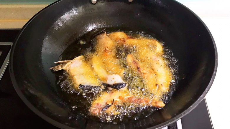 红烧鱼块,待油温降至7分热的时候加入鱼段，小火炸至两面金黄