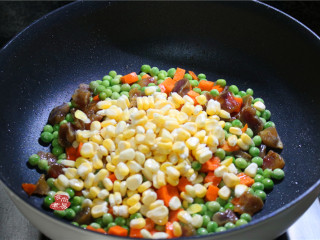 蔬菜腊肠饭,将玉米粒倒入锅中