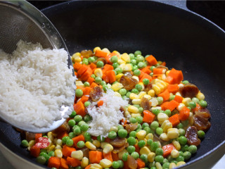 蔬菜腊肠饭,将大米沥干水，倒入锅中