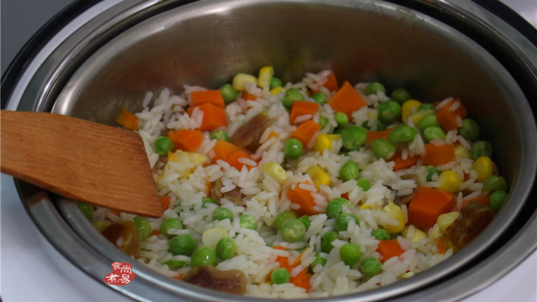 蔬菜腊肠饭,将锅中的米饭连同米汤倒入脱糖饭煲中，用木铲拌均匀
