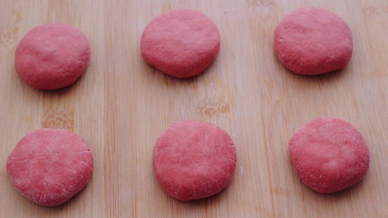 粉嫩蔓越莓果仁芝麻饼,依次包好所有的饼胚后，用手摁扁。