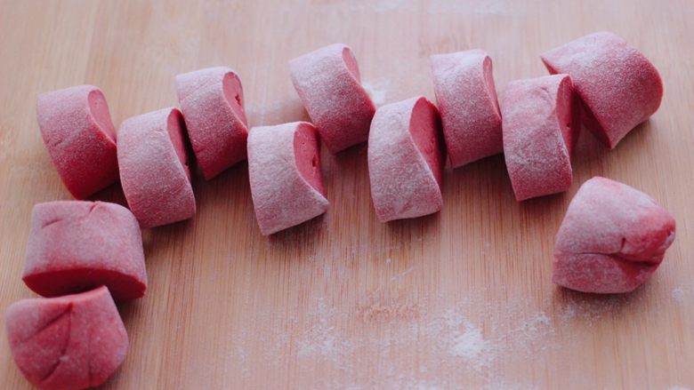 粉嫩蔓越莓果仁芝麻饼,把醒发好的面团排气揉匀后，用手搓成长条，用刀切成大小一致的剂子。