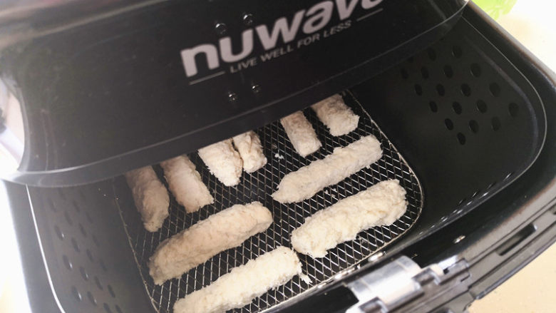 炸鱼柳,将空气炸锅先预热，温度设在200度，预热好以后将鱼柳摆放在烤网上，