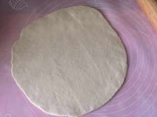 自制披萨,面团发酵至两倍大后取出揉匀排气，分成两份，分别用擀面杖擀成圆形面皮；