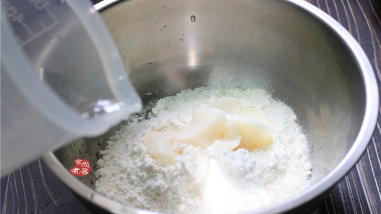蛋黄酥,接着做水油面团，将低筋面粉、糖粉、猪油倒入盆中，分次加入少量清水。