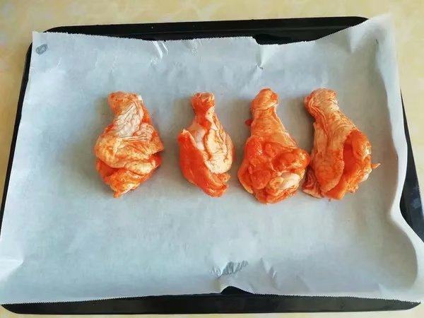 韩式泡菜风味烤翅根, 烤盘铺上油纸，摆上鸡翅根，放入预热好的烤箱中层，200度烤十分钟。