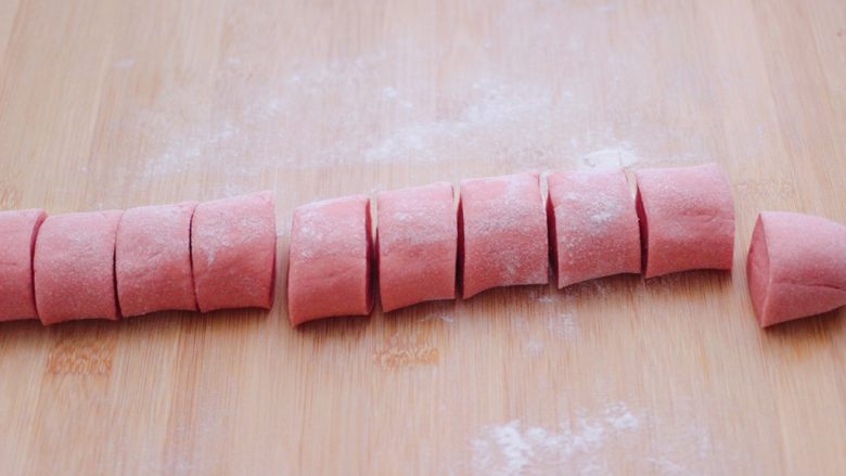 粉嫩茴香猪肉麦穗包,把醒发好的面团排气揉匀后，用手搓成长条后，用刀切成大小一致的剂子。