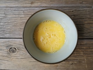 五彩拉皮,鸡蛋打入碗中，打散成蛋液。