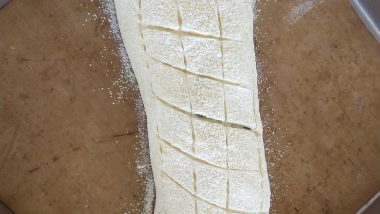 全麦豆沙软欧,11、发酵好后表面撒高粉，用割包刀划出格子状。
