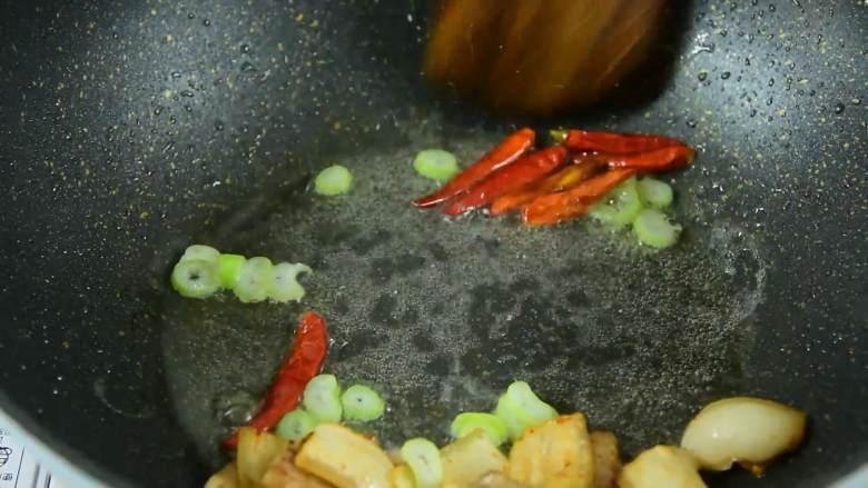 这样荤素搭配的小炒最适合工作日带饭了,五花肉推至锅边，倒入葱花、干辣椒炒香。