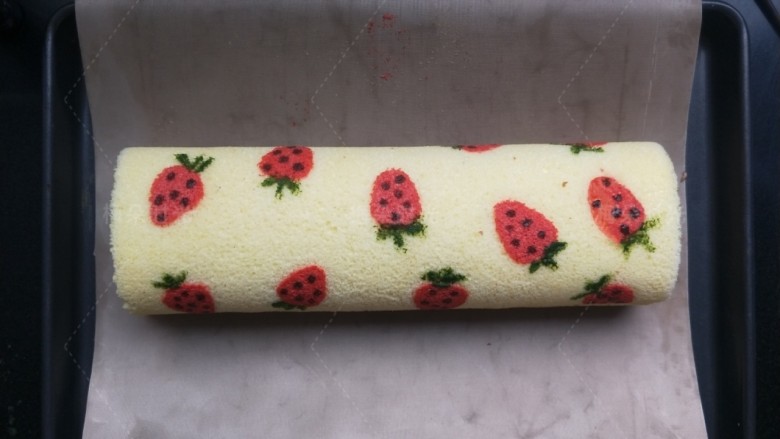 草莓彩绘蛋糕卷,用小刷子蘸绿色的液体画出草莓叶子。用筷子头蘸可可粉点出草莓籽。