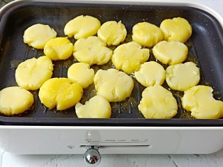 家常菜【香辣小土豆】,依次码上土豆饼，全程开大火煎。