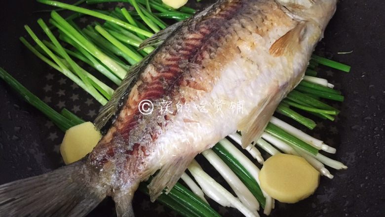 葱烤鲫鱼,出香味后把鱼放在小葱上。