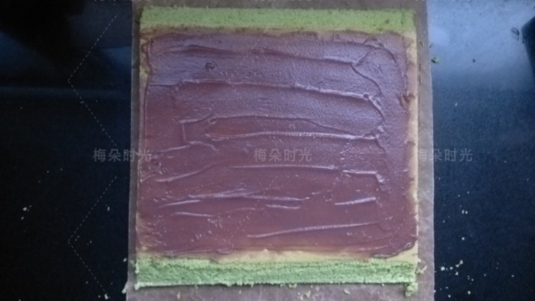 唐草彩绘蛋糕卷,把豆沙馅均匀的抹在蛋糕表面。然后卷起来。