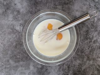 奶香吐司布丁,将鸡蛋打入牛奶中拌匀