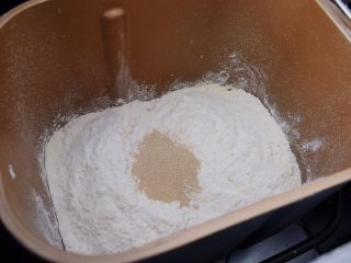 豆沙吐司面包,把材料除黄油和豆沙馅外，其它材料投入面包机中，运行揉面程序10分钟