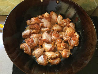 泰式香辣风味烧鸡翅,炒锅加注入食用油，下姜片爆锅后下腌好的鸡翅