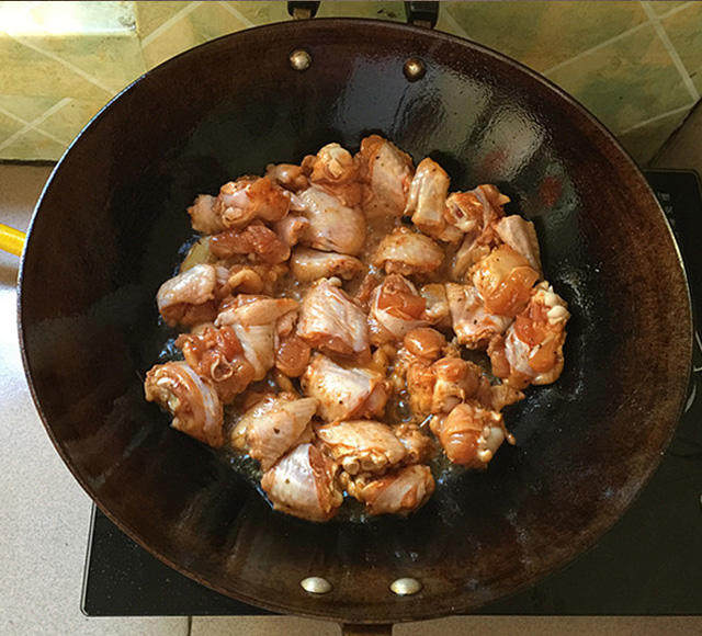 泰式香辣风味烧鸡翅,炒锅加注入食用油，下姜片爆锅后下腌好的鸡翅