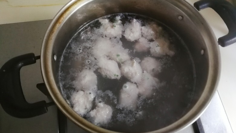 蚕豆仁汆汤丸子,锅中水开，用勺子挖肉糜尽量弄圆一点，放入锅中烧开至漂浮起来