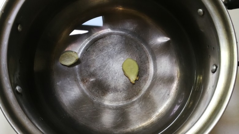 肉圆青蚕豆米汤,锅中放入清水和姜片