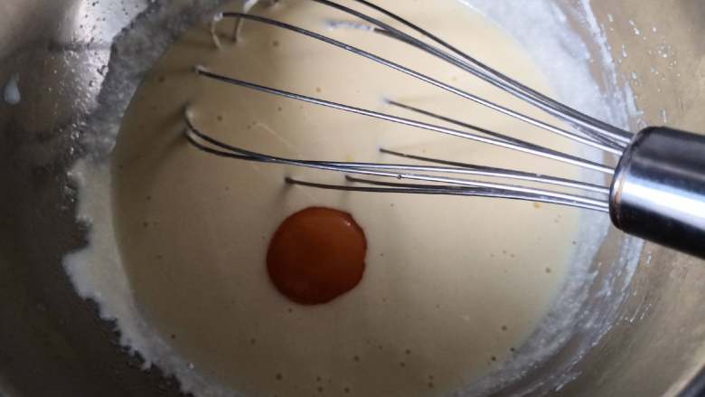 空气感轻乳酪蛋糕,分两次加入蛋黄，将蛋黄糊搅拌均匀
