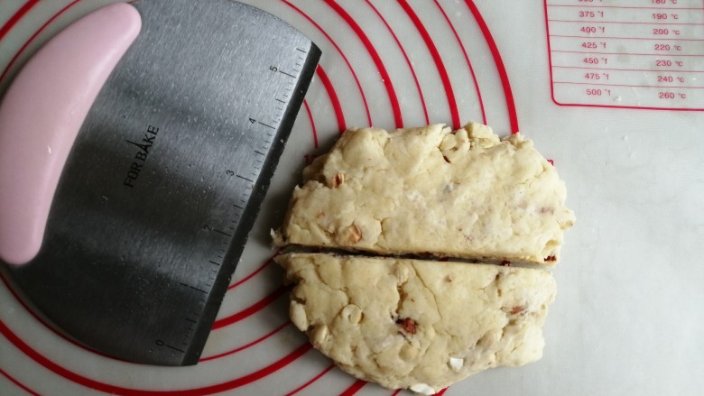 什锦坚果司康饼,用手压扁平一点，用刮刀切成两半。