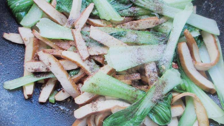 青菜炒豆干,加入生抽、蚝油和少许盐、胡椒粉调味不停翻炒