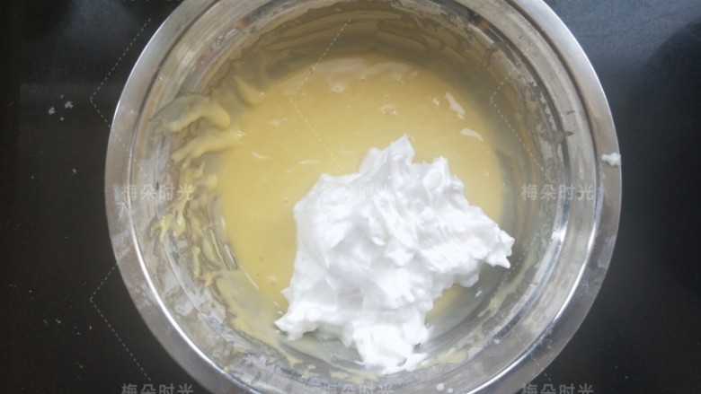 奶油纸杯蛋糕,挖三分之一蛋清加入蛋黄糊里面，翻拌均匀。然后再挖三分之一加入。