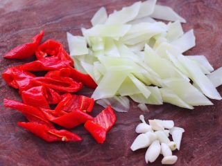 鸡胗爆莴苣,莴苣去皮后洗净，用刀斜切成薄片，红辣椒切片，大蒜去皮后切成薄片。