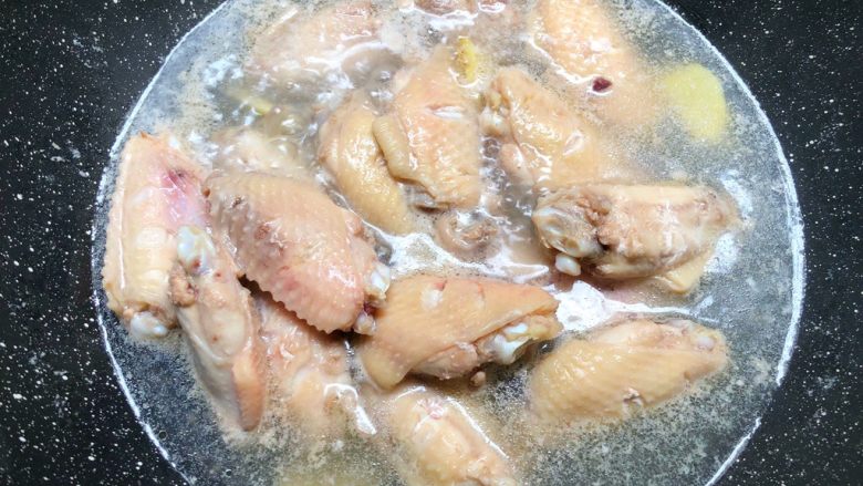 蒜香蚝油鸡翅,把鸡翅放入锅里，放入姜片，倒入适量水，大火把水煮开，把鸡翅煮出血沫，煮出血沫以后，用清水冲洗干净沥干水待用。