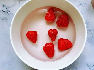 【酸奶水果条】,将草莓用盐水浸泡片刻，然后冲洗干净沥干水备用，红提和蓝莓也清洗干净沥干水备用。