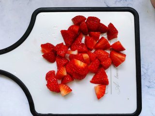 【酸奶水果条】,将沥干水的草莓切成丁。