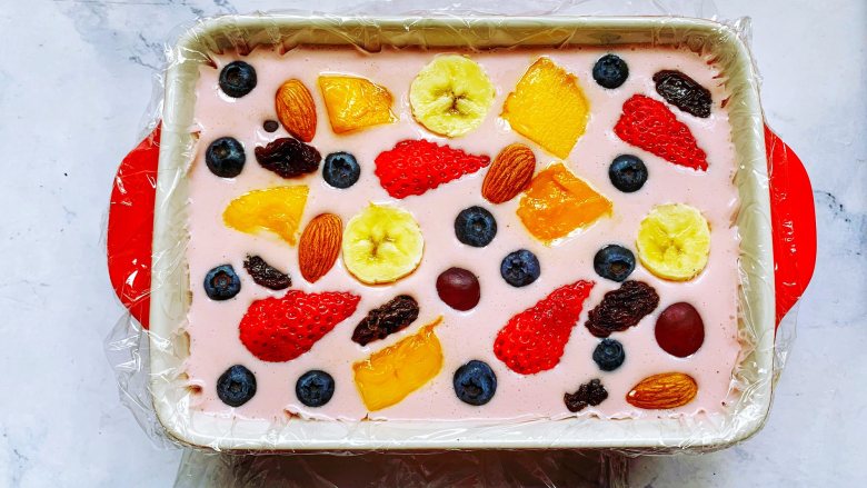 【酸奶水果条】,表面铺上切好的水果、坚果和果干。