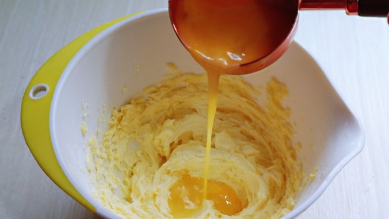 黑芝麻核桃饼干,分两次加入全蛋液，继续启动电动打蛋器，打至蛋液与黄油完全融合，再加入一半蛋液，同样打至完全融合即可。