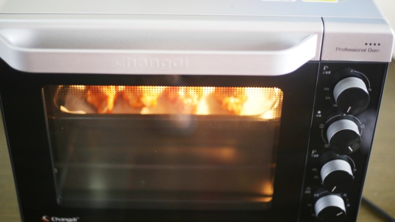 骨头都啃光的奥尔良鸡翅根,烤盘铺上油纸，摆好鸡翅根。放入预热好的烤箱，180度烤20分钟。