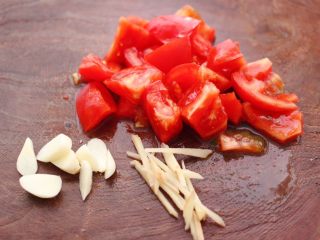 菜花番茄海虾小炒,把番茄洗净后用刀切成小块，大蒜切成薄片，姜切丝。