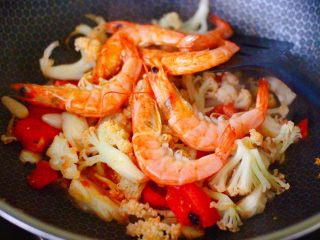 菜花番茄海虾小炒,继续大火翻炒片刻，加入煎好的海虾。