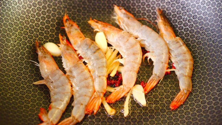菜花番茄海虾小炒,把洗净的海虾放入锅中，用小火慢慢煎制。