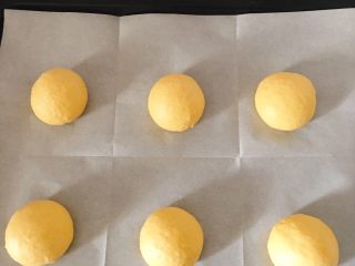南瓜卡通面包,将面团平均分成50克一个的小面团
盖保鲜膜松弛15分钟