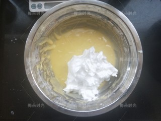 纸杯蛋糕（不塌不裂）,挖三分之一蛋清加入蛋黄糊里面，翻拌均匀。然后再挖三分之一加入。