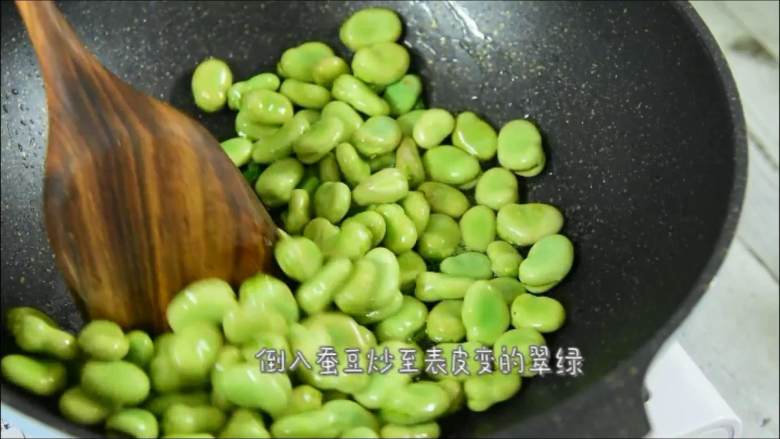 一不留神就错过了吃蚕豆的最佳时节，且吃切珍惜,倒入蚕豆炒至表皮变的翠绿。