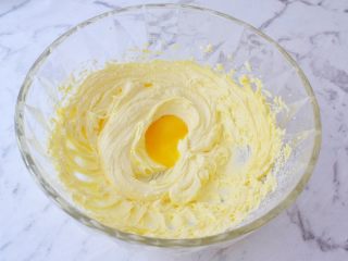 猕猴桃饼干,将蛋黄打散后分二次加入到打发好的黄油中，用电动打蛋器搅打均匀，每次都要搅打到蛋黄液充分融合到黄油里，才能加入下一次蛋黄液