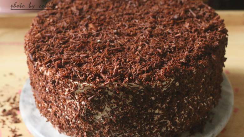 黑森林蛋糕,然后粘上一层巧克力屑，上面用自己喜欢的裱花嘴花型挤一圈奶油，中间放上樱桃和酒渍樱桃装饰
