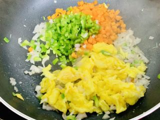 风味牛肉肠焗饭,加入青椒粒、胡萝卜粒在次翻炒炒一分钟。