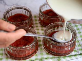 草莓牛奶布丁,用勺子缓冲一下，倒入牛奶布丁液。