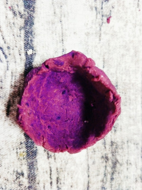 紫薯仙豆糕,用手将小份紫薯团按压，成凹陷装