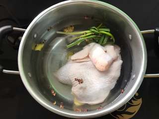口水鸡,锅中倒入适量水，放入葱结，花椒和老姜，把鸡一起放入。