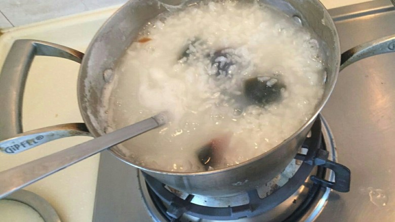 香滑皮蛋培根粥,放入锅中。搅拌。