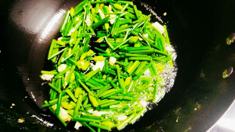 韭菜花炒鸡蛋,另起一锅，锅中倒油，油热后蒜爆香，然后加入韭菜花，翻炒1分钟